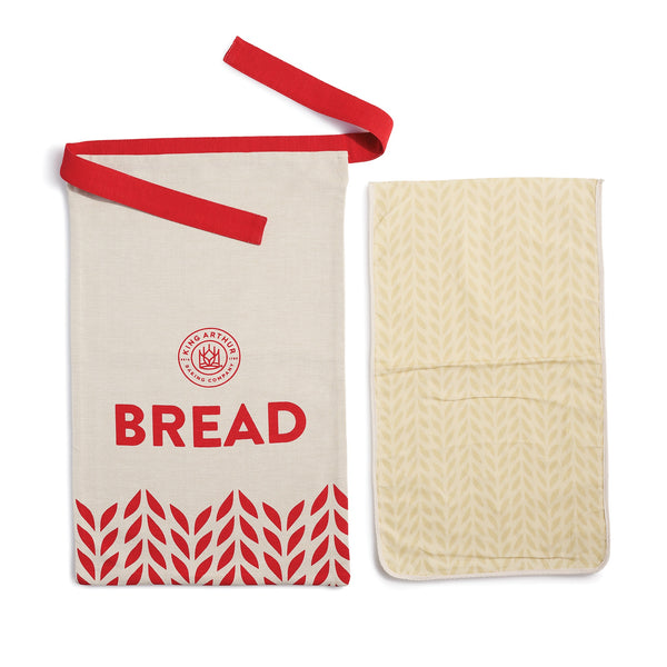 Bread bag with red strap and 'BREAD' text, next to a quilted bread board on a white background