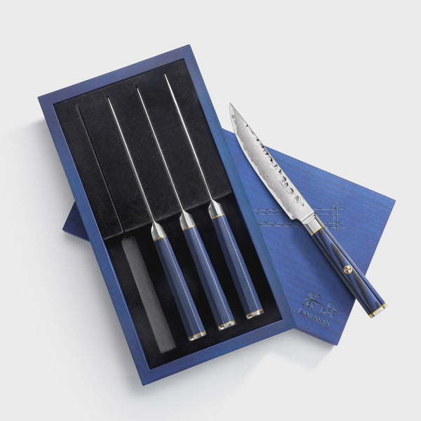 Set of steak knives with blue handles and silver blades on a white background from Cangshan