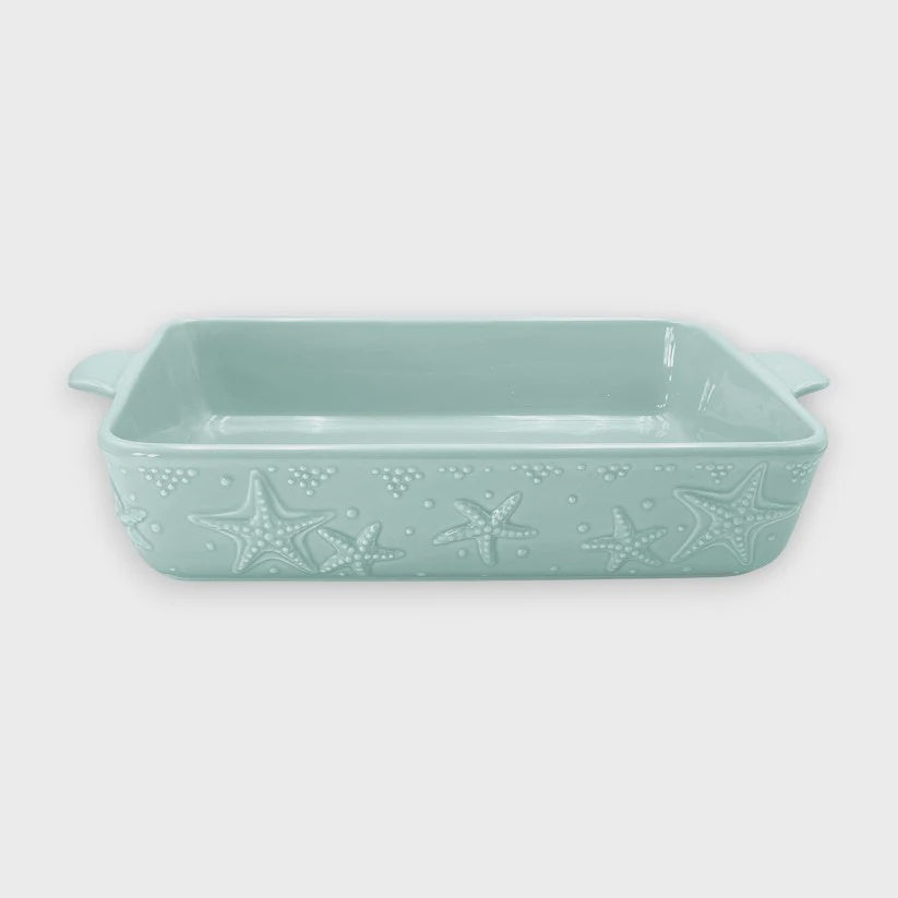 Mint green ceramic casserole dish with starfish design on a white background