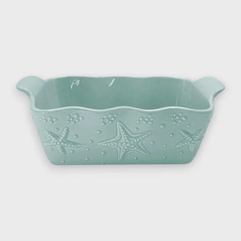Mint green ceramic loaf pan with starfish design on a white background